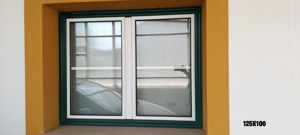 Janelas em alumínio, brancas e verdes, com veda luz interior.
