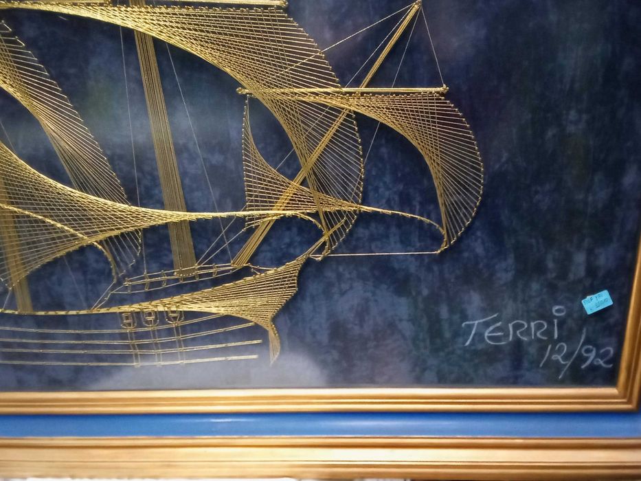 Quadro construído com fio dourado a representar uma caravela Portuguesa