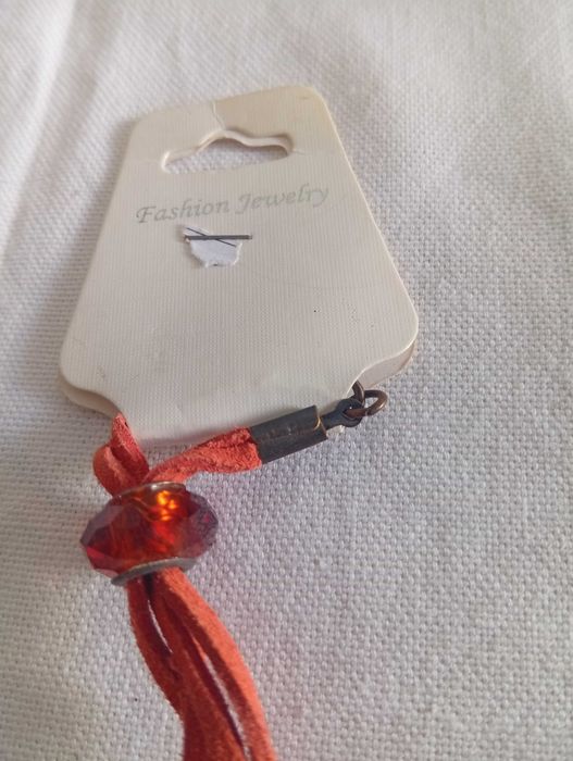 Pingente artesanal, em vidro fundido, colorido, com cordão de couro, em laranja.
