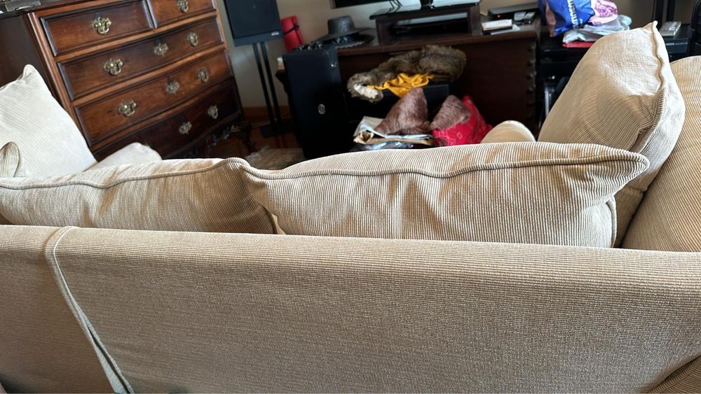 Sófá em tecido com almofadões de penas.