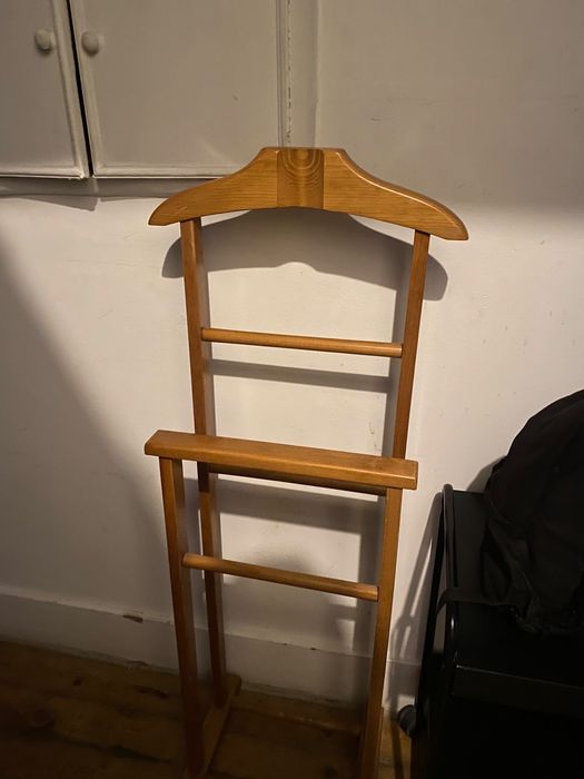 Um cabideiro de chão e mesa de apoio