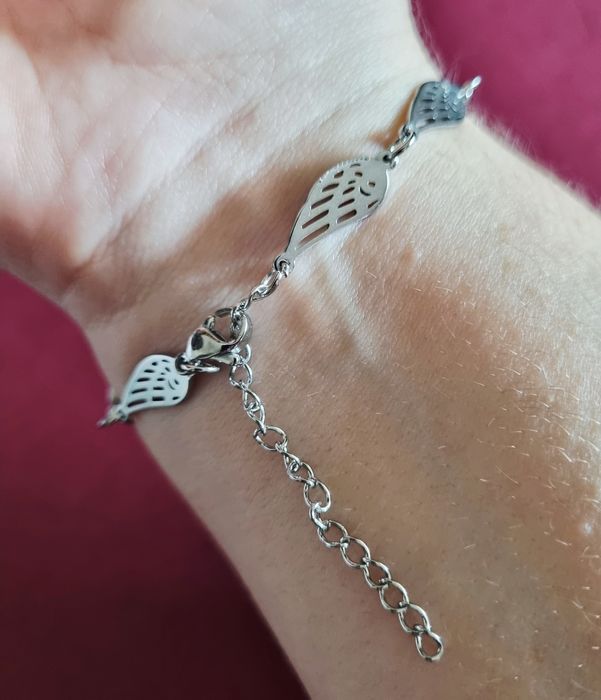 Conjunto prateado (colar e pulseira), em aço,  com asas de anjo.