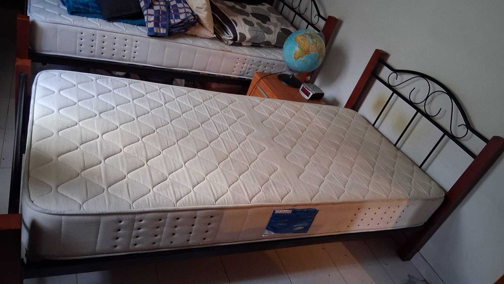 Camas de solteiro em madeira e ferro com colchões