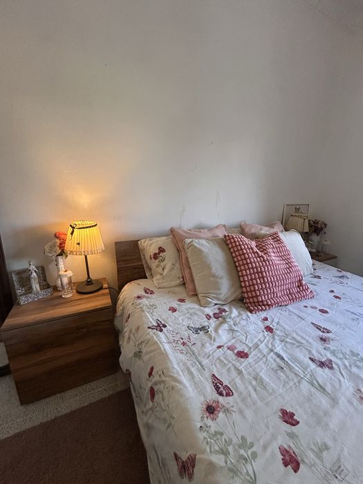 Quarto casal com mesas de cabeceiras e cómoda.