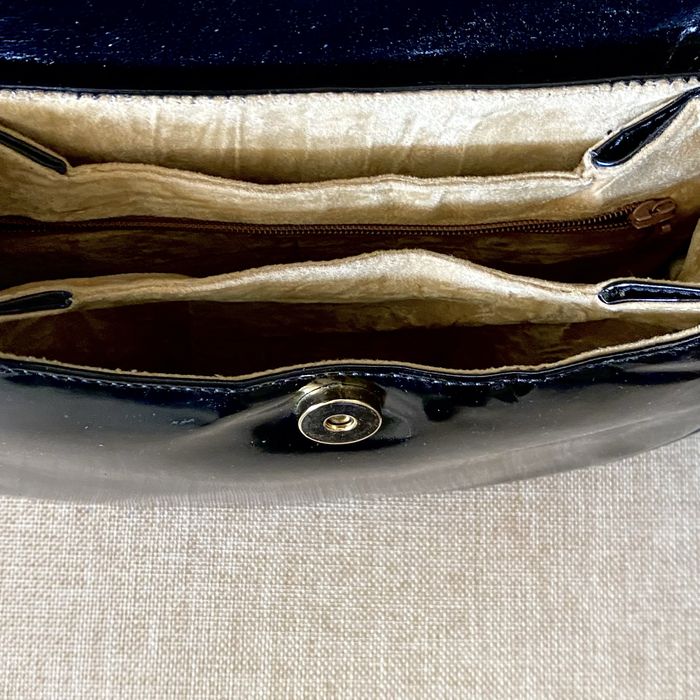 Bolsa em pele, Aries, com acabamento em verniz e fecho magnético.