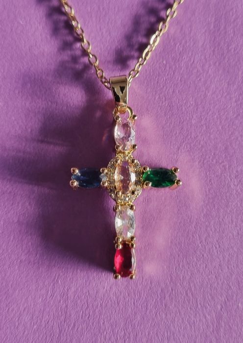 Colar dourado, em aço, com cruz colorida. Tem extensor.