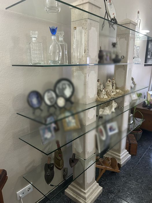 Estante de vidro com pilares de pedra