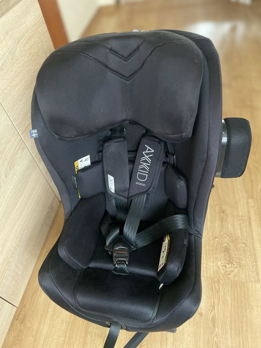 Czarny fotelik samochodowy axkid minikid tylem na pasy