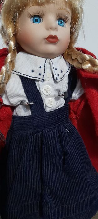 Boneca loiça e pano, com suporte em metal