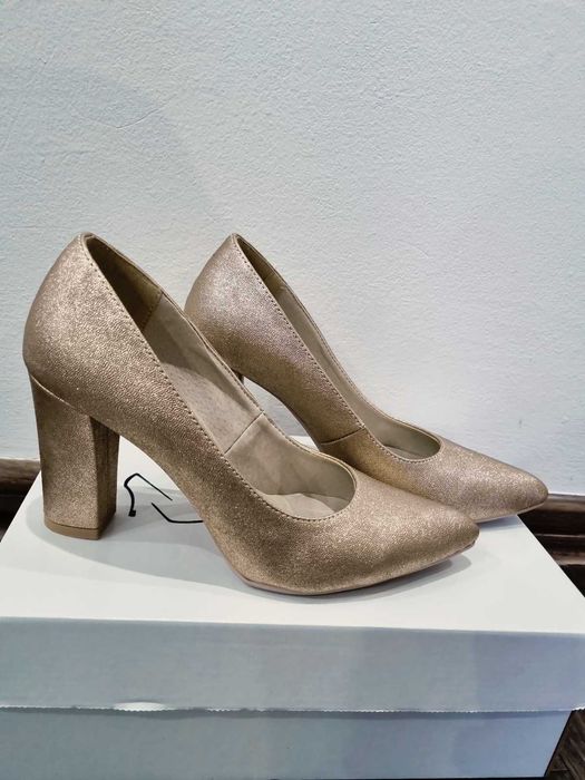Złote eleganckie buty na słupku