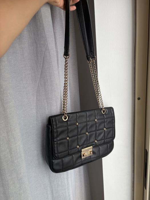 Mala Guess preta e dourada