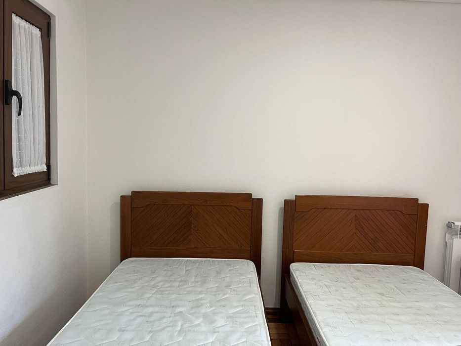 2 camas individuais com uma mesa de cabeceira