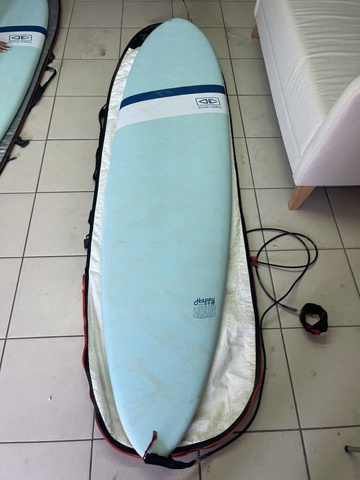 Prancha de surf Ocean & Earth Happy Hour Epoxy Softop 7.6 (59L) em bom estado geral, vendida com capa de proteção.