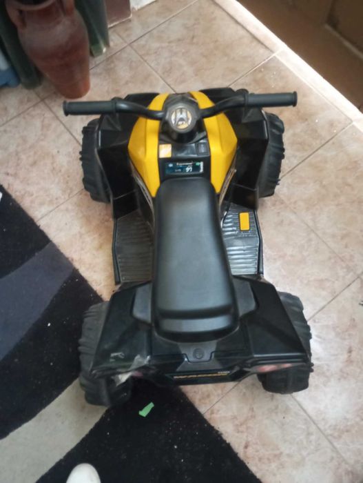 Moto quatro a bateria e uma pista de carro iluminosa praticamente nova