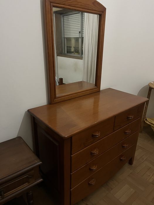 Cama de casal com mesinhas de cabeceira e comoda.