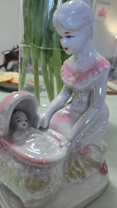 Figurka porcelanowa przedstawiająca matkę pochylającą się nad dzieckie