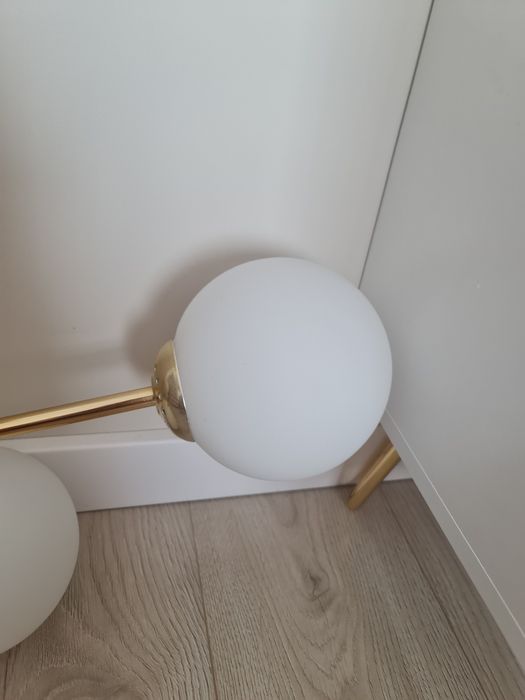 Zlota lampa sufitowa z bialymi kloszami