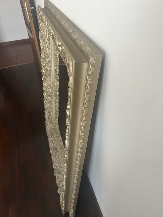 Espelho com moldura dourada.