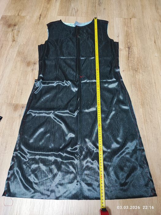 Недошита сукня з блискучої стальної тканини.