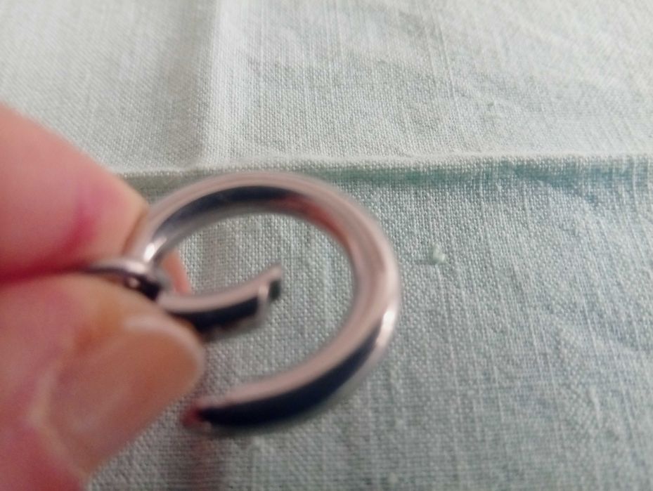 Pulseira em metal prateado, com aros e 2 argolas