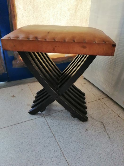 Banco antigo em madeira com estofo de pele.
