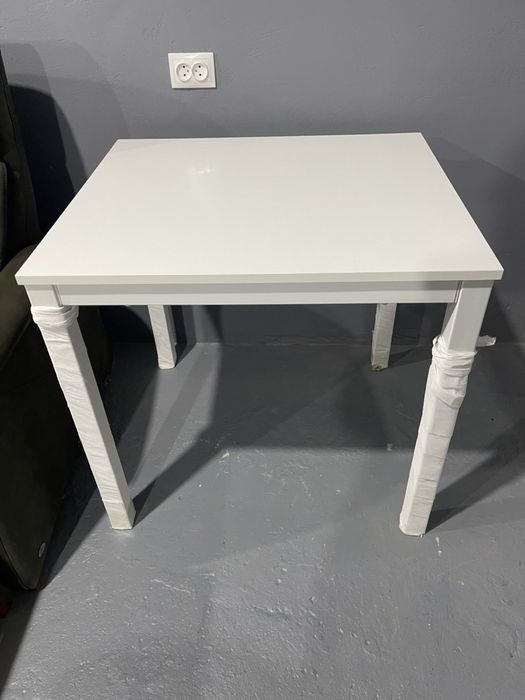 Білий розкладний обідній стіл.