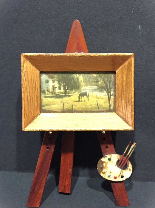 Pequeno cavalete com um pequeno quadro antigo