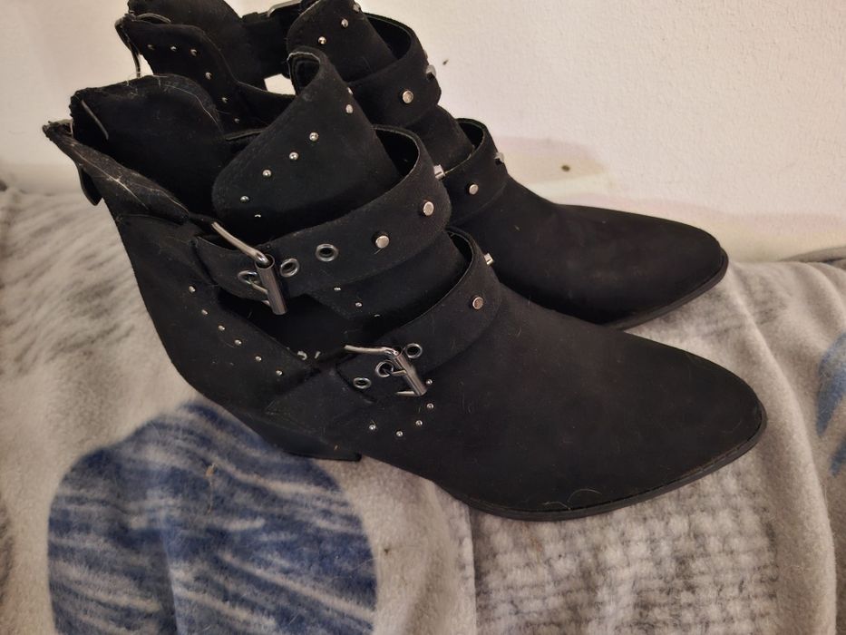Botas pretas com fivelas e pitons