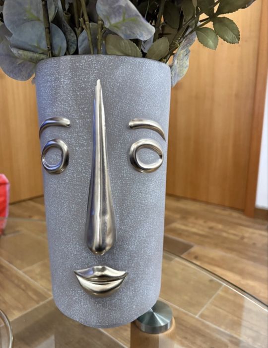 Vaso decorativo com rosto e flores artificiais
