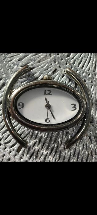 damski zegarek w stylu bransoletki (bangle watch) z owalną kopertą w kolorze srebrnym.
