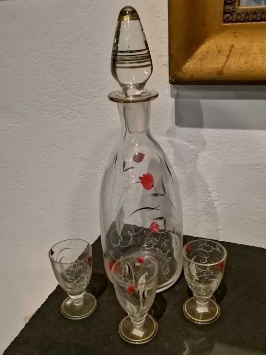 Garrafa de licor e três copos em vidro