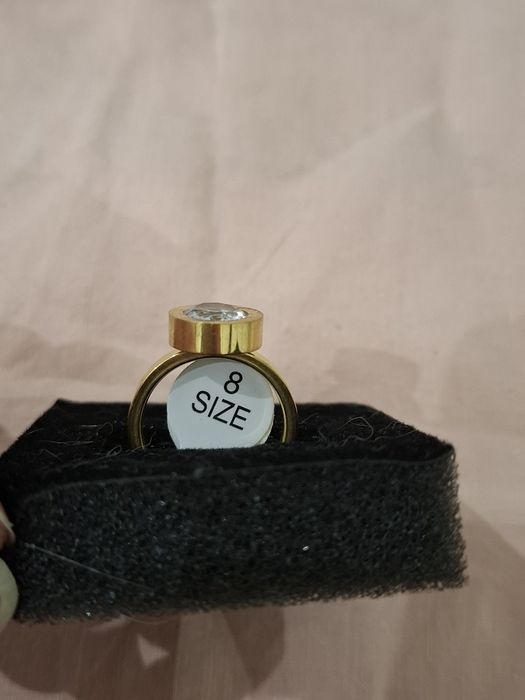 Anel dourado com brilhante e números romanos em Aço Novo