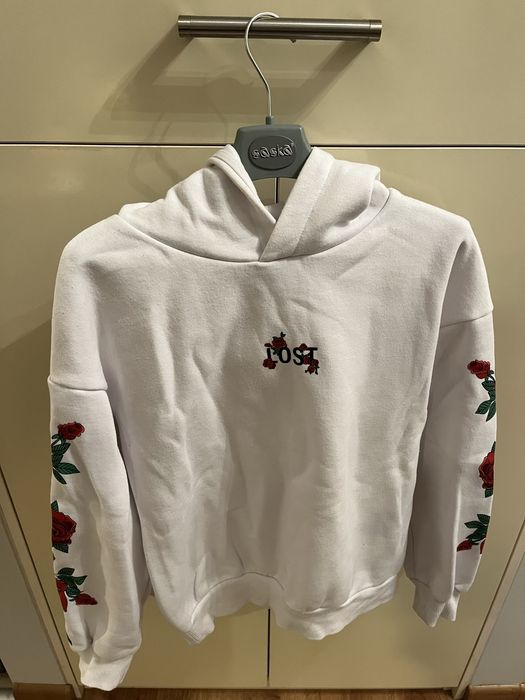 białą bluzę z pięknymi czerwonymi różami na rękawach