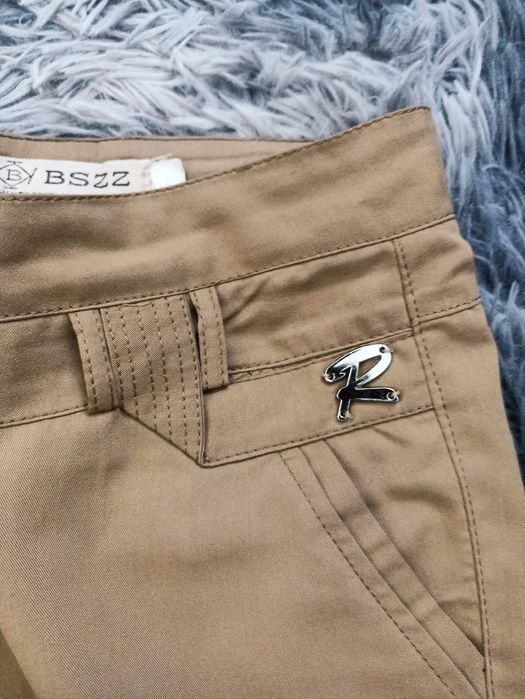 Жіночі брюки гірчичного кольору.