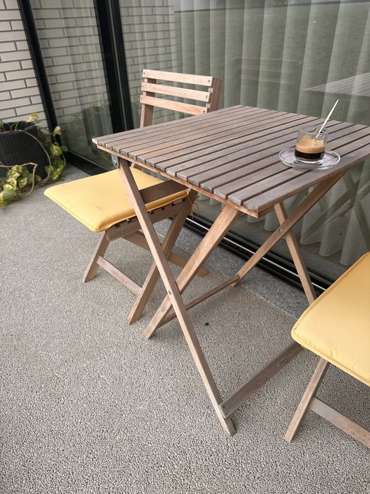 Mesa com duas cadeifas e almofadas