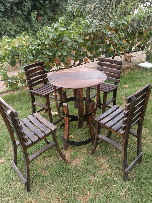 Cadeiras altas e mesa rústicas feitas de madeira de pipos