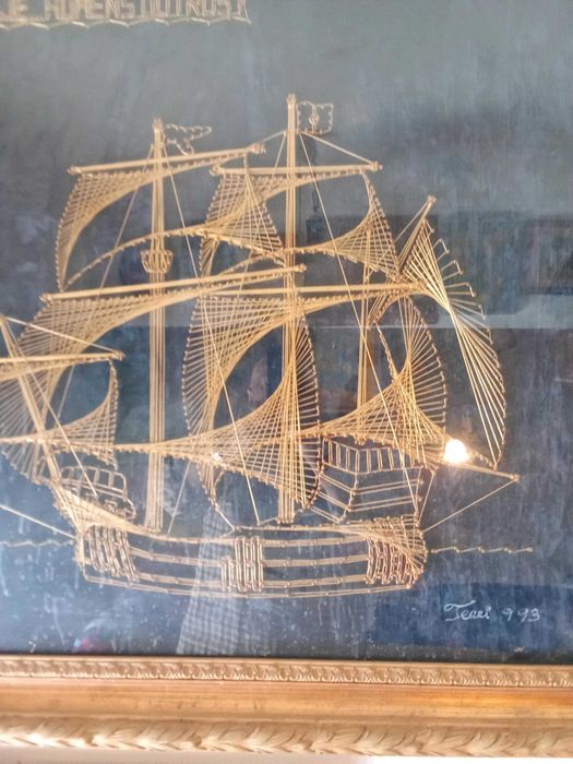 Quadro monumento aos descobrimentos construído com fio dourado.