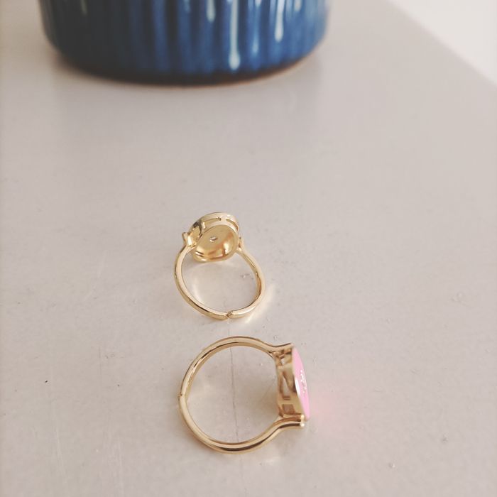 Dois anéis em latão dourado e esmalte rosa e azul.