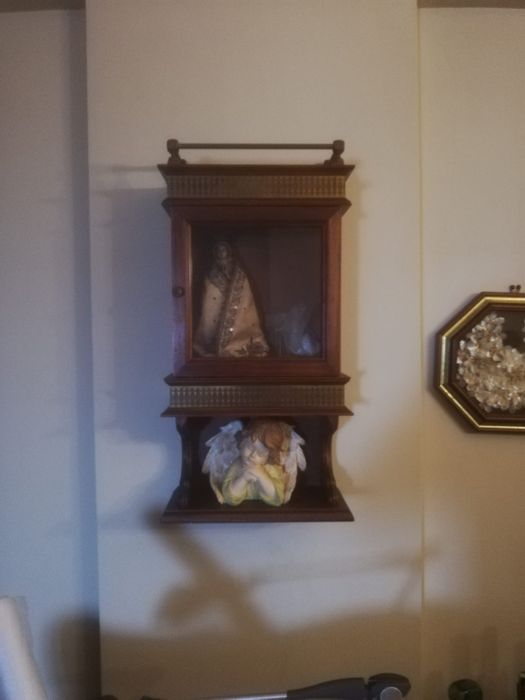 Móvel em madeira, com porta envidraçada.