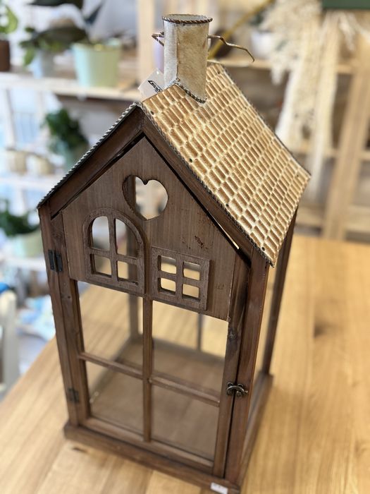 Drewniany lampion z metalowym dachem i szklanymi szybami