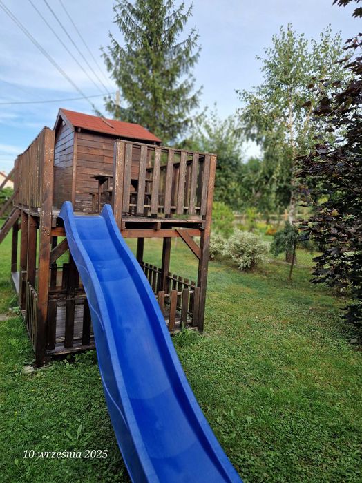 Duży drewniany domek dla dzieci z huśtawką