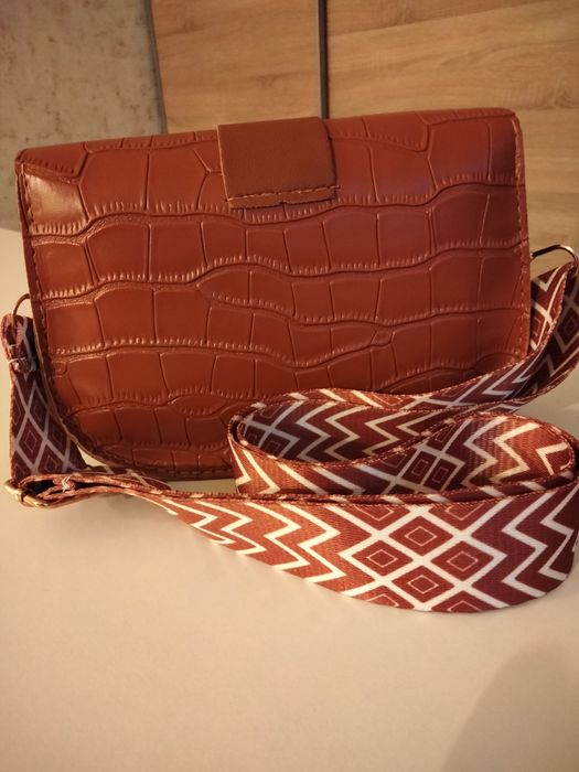 Brązowa torebka typu listonoszka.