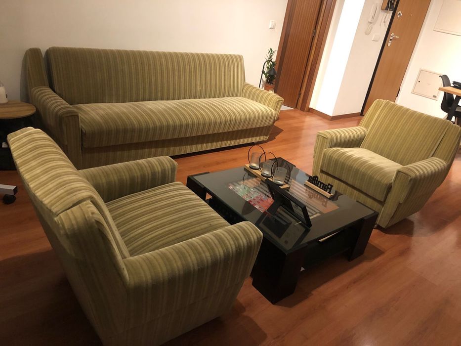 sofá-cama e dois sofás verdes.