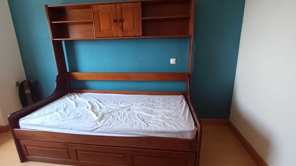 Estúdio em madeira, com estrados, colchões, gavetão e estante.