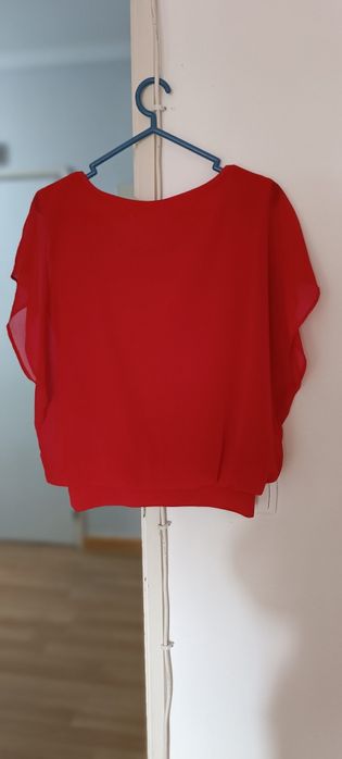 Camisola vermelha aberta de lado usada. Não tem etiqueta, mas veste M.