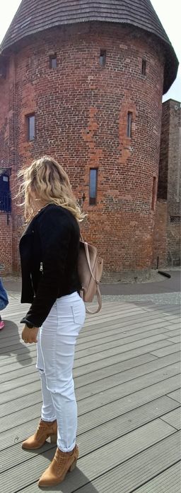 Białe spodnie z diurami na kolanach