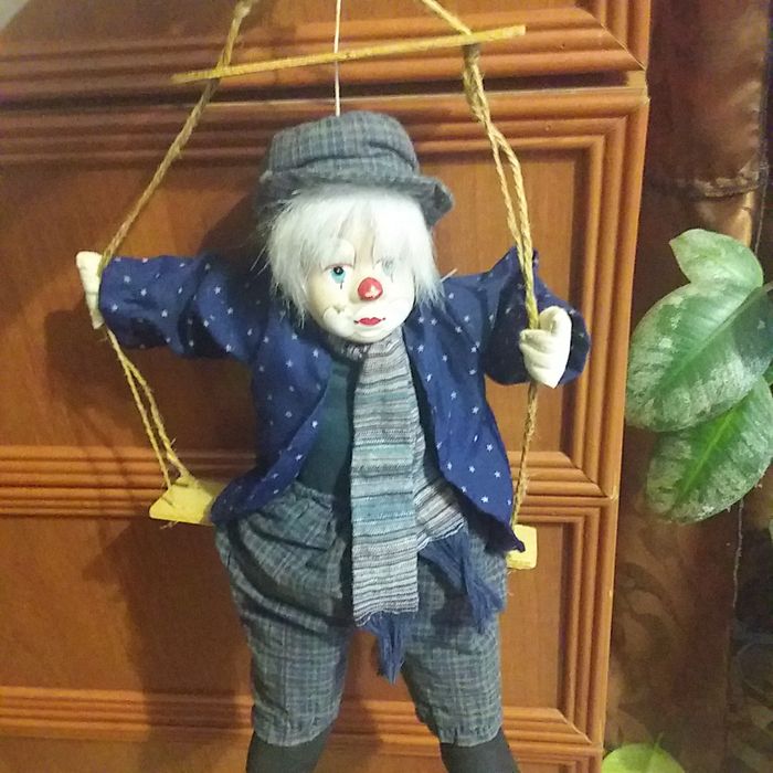 Игрушка клоун на качеле.