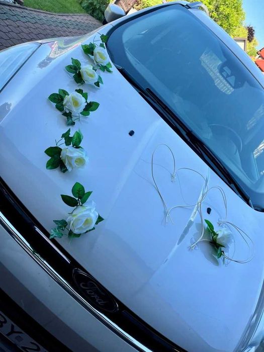 Delikatna dekoracja samochodu ślubnego stroiki kwiaty auto serca