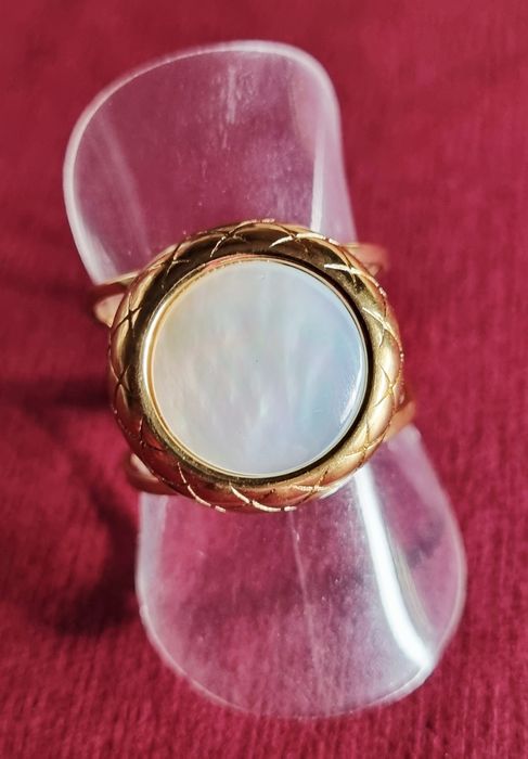 Anel dourado, em aço, com madrepérola redonda. Ajustável
