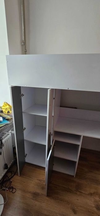 Łóżko piętrowe z biurkiem i szafą.